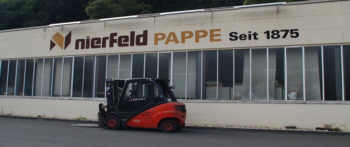 Vor weißer Halle mit der Aufschrift