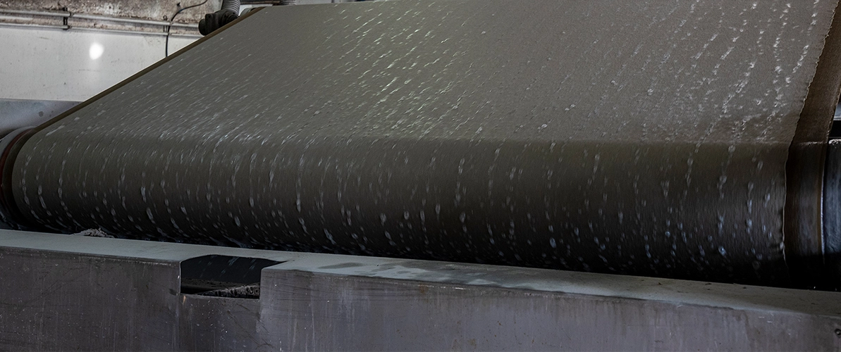 Vollautomatische Pappenmaschine - dunkle Pappe auf einer Rolle der Maschine.